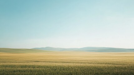 Obraz premium A wide-open field with rolling hills and a clear sky, offering ample space for text in the sky or foreground.