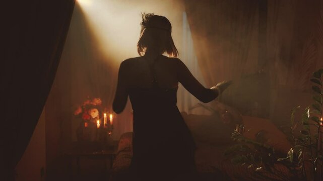 Old film style black dark female silhouette dancing. fashion model sexy vintage dress fringe waving. retro young happy woman dancer at night club party have fun. room full smoke back light rays flare