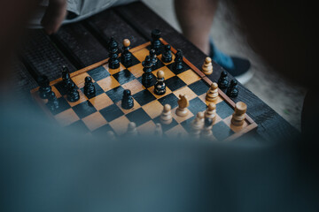 Close-up of a chess game on a wooden board outdoors. Strategic thinking and planning in focus...