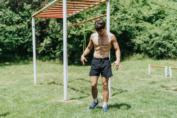 Fit male sports person working out in a park, enjoying an outdoor exercise routine on a sunny day