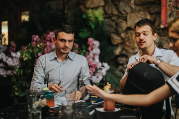 A group of colleagues engaging in a casual business meeting in a cozy cafe surrounded by floral decor, fostering a relaxed and creative environment.