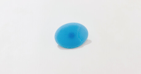 Blue silicone face cleansing pad with soft bristles on white background, ideal for skincare routines.