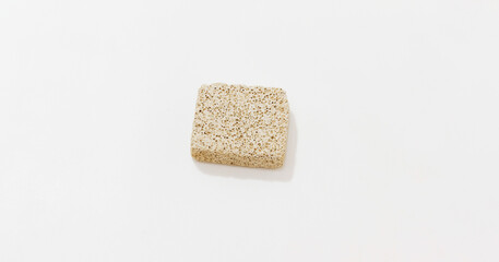 Close up of beige pumice stone on plain white background.