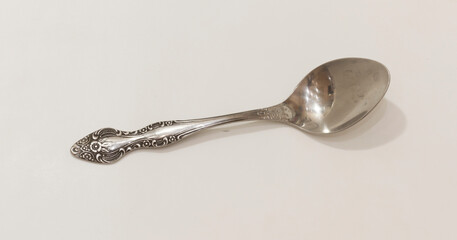 Ornate silver spoon with intricate floral design on the handle, ideal for vintage themed table settings or decor.
