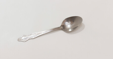 Elegant silver spoon with intricate floral design, suitable for classic table settings or vintage decor themes.