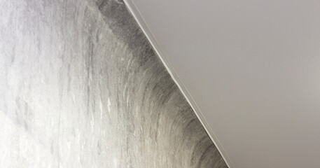 Textured wall meets ceiling at an angle, featuring modern, minimalist interior design with soft lighting.