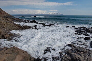 Russia. The Far East. The Kuril Islands. Waves of the Pacific Ocean beating against basalt rocks on the shore of Iturup Island.