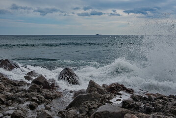 Russia. The Far East. The Kuril Islands. Waves of the Pacific Ocean beating against basalt rocks on the shore of Iturup Island.