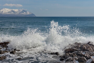 Russia. The Far East. The Kuril Islands. Waves of the Pacific Ocean beating against basalt rocks on the shore of Iturup Island.
