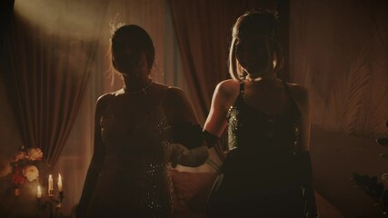 Dark silhouette two women walking at night club evening ball dark room Happy Girl have fun at old retro style party roaring twenties holiday 1920. Woman in shiny black dress. Sexy girls leaving event