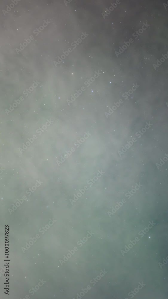 Wall mural a vertical format time lapse clip of the aurora, with stars and thin moon lit clouds. only the sky i