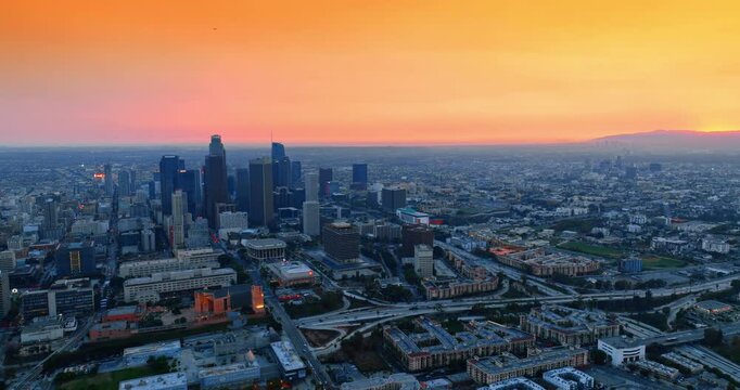 Orange sky above the scenery of a huge metropolis. Panorama of Los Angeles, California, USA.
