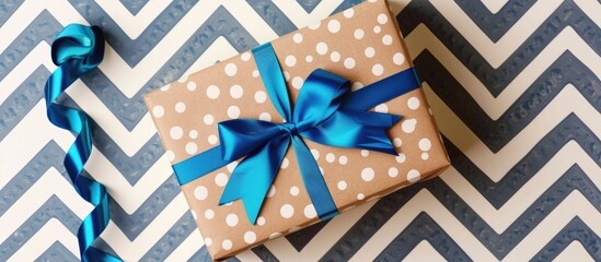 Obraz premium Happy Father S Day Greeting Card With Decorated Gift Box And Tied With Blue Bow On Zigzag Striped Background Top View