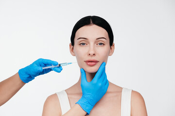 Woman while procedure lip augmentation at cosmetology clinic with beautician. Filler injection for...