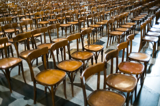 Filas de sillas de madera alineadas en un gran auditorio o iglesia, concepto de multitud y evento