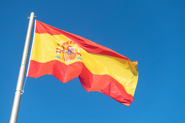 Flag of Spain flying in the wind with a blue sky background...country, land, spanish,Espa&ntilde;a