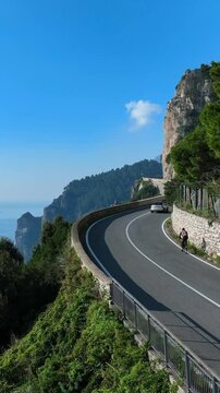 ciclista in bicicletta travels along the curves of the Amalfi Coast Panoramic Road.
Aerial view of the curves overlooking the sea of ​​the coast.