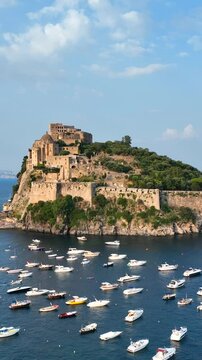 Ischia, Golfo di Napoli, Italia, l'isola con il castello Aragonese.
Vista aerea da drone, Composizione verticale, dell'isolotto di Ischia.
