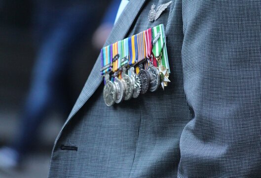 Sydney, NSW Australia - April 25 2021: Anzac Day March. A man in a grey suit wearing medals and rosemary