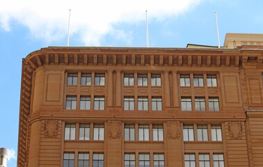 Historic commercial sandstone building with flag poles © Rose Makin