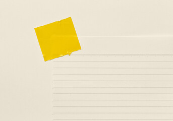 Blank Notepad with a Yellow glue tape affixed at the top on white Background.