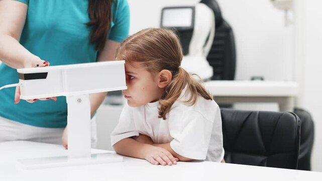 A girl participates in an engaging vision enhancement therapy using cutting-edge equipment. This laser treatment aids in restoring and developing visual skills.