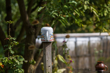 Beautiful garden. There are mugs on the post.