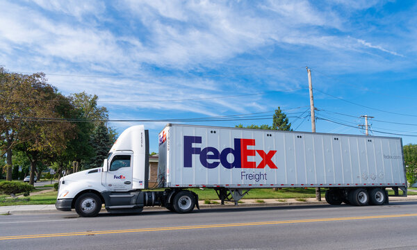 Chicago, USA - August 21, 2024: Truck with FedEx container on truck on the road. FedEx Corporation, a U.S.-based logistics company with international coverage. Federal Express is leader company
