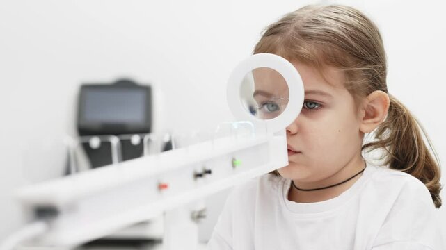 A little girl enjoys an engaging vision game on state-of-the-art ophthalmic equipment. The "Rainbow" system enhances eyesight in a comfortable and welcoming environment.