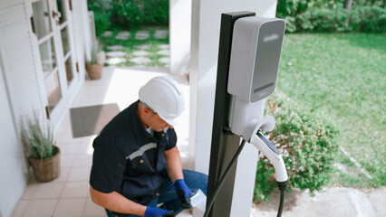 Qualified technician install home EV charging station, providing maintenance service for electric...
