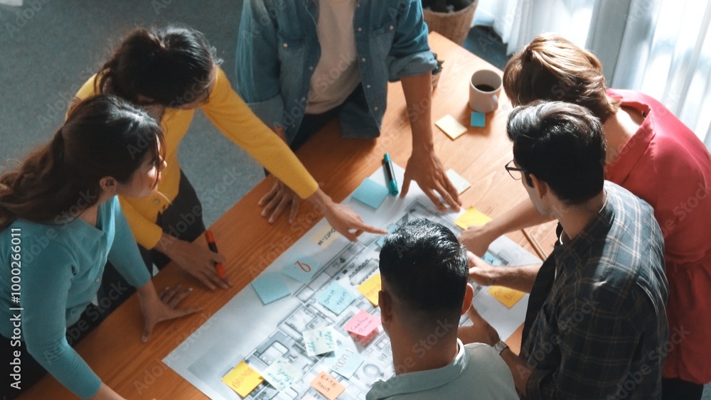 Poster top view of civil engineer team writing at blueprint at meeting table with color palettes. group of 