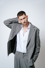 Fashion man model in grey suit, shoot in studio