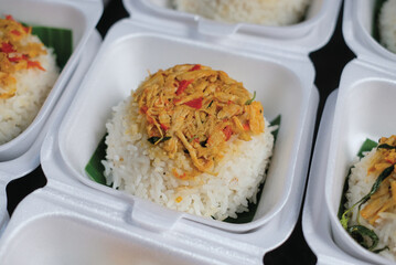 Boxed rice. Rows of packaged rice boxes, spicy seasoned shredded chicken.