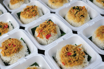 Boxed rice. Rows of packaged rice boxes, spicy seasoned shredded chicken.