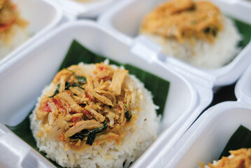 Boxed rice. Rows of packaged rice boxes, spicy seasoned shredded chicken.
