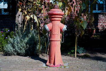 Old red orange colored hydrant to protect the inhabitants in case of fire in the town of Neu...