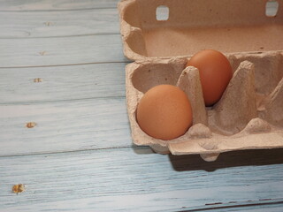  chicken eggs in an egg box on wooden background. High quality photo