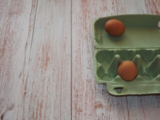  chicken eggs in an egg box on wooden background. High quality photo