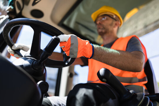 Construction worker operating heavy machinery at a construction site during daytime