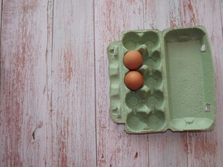  chicken eggs in an egg box on wooden background. High quality photo