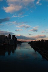 Fototapeta premium River nature sky and sunset with buildings and city skyline, reflection of sky in river dark blue backround