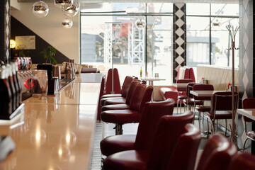 Sleek interior dining area with glossy countertops and red chairs lined along clean, modern design creating inviting atmosphere, ideal for having meal and conversation