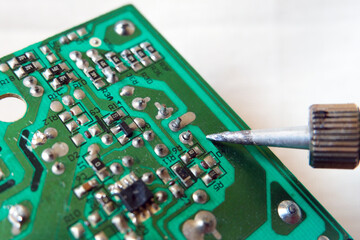 Failed solder joints on the broken electronic circuit board. Cold solder joint. Focused on soldered...