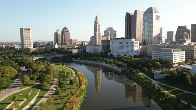4k drone footage of a city reflecting off the downtown river in the morning with cinematic lighting in columbus ohio 2024