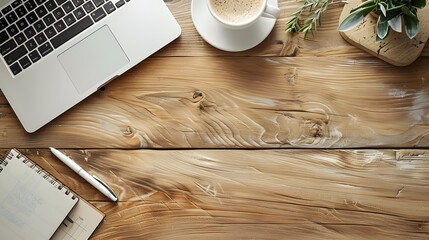 Flat lay of workspace essentials including laptop, coffee, and notepad on rustic wooden surface. Cozy office setting with copy space. Ideal for blogs, banners, and marketing materials