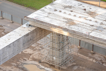 Construction of a light metro bridge in Astana, with a concrete pillar reinforced by scaffolding, showcasing an unfinished section of the elevated track. Kazakhstan