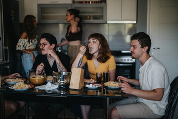 A group of young friends enjoying a casual pasta dinner in a warm, inviting kitchen setting. They share laughter and conversation, creating a sense of connection and friendship.