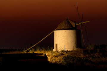 Windmill illuminated at night with the last lights of sunset in the white beautiful village of Vejer de la Frontera, Cadiz province, Andalusia, Spain