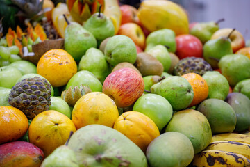 assorted fruits coconut, apple, papaya, grape, kiwi, orange at a street market stall in Rio de Janeiro.