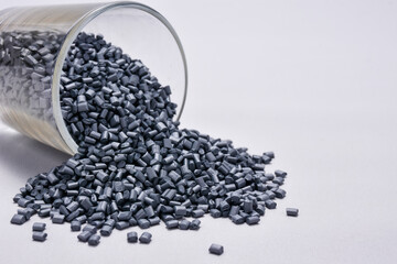 pearl silver masterbatch granules spilled from a shot glass, isolated on a white background, this polymer is a colorant for products in the plastics industry